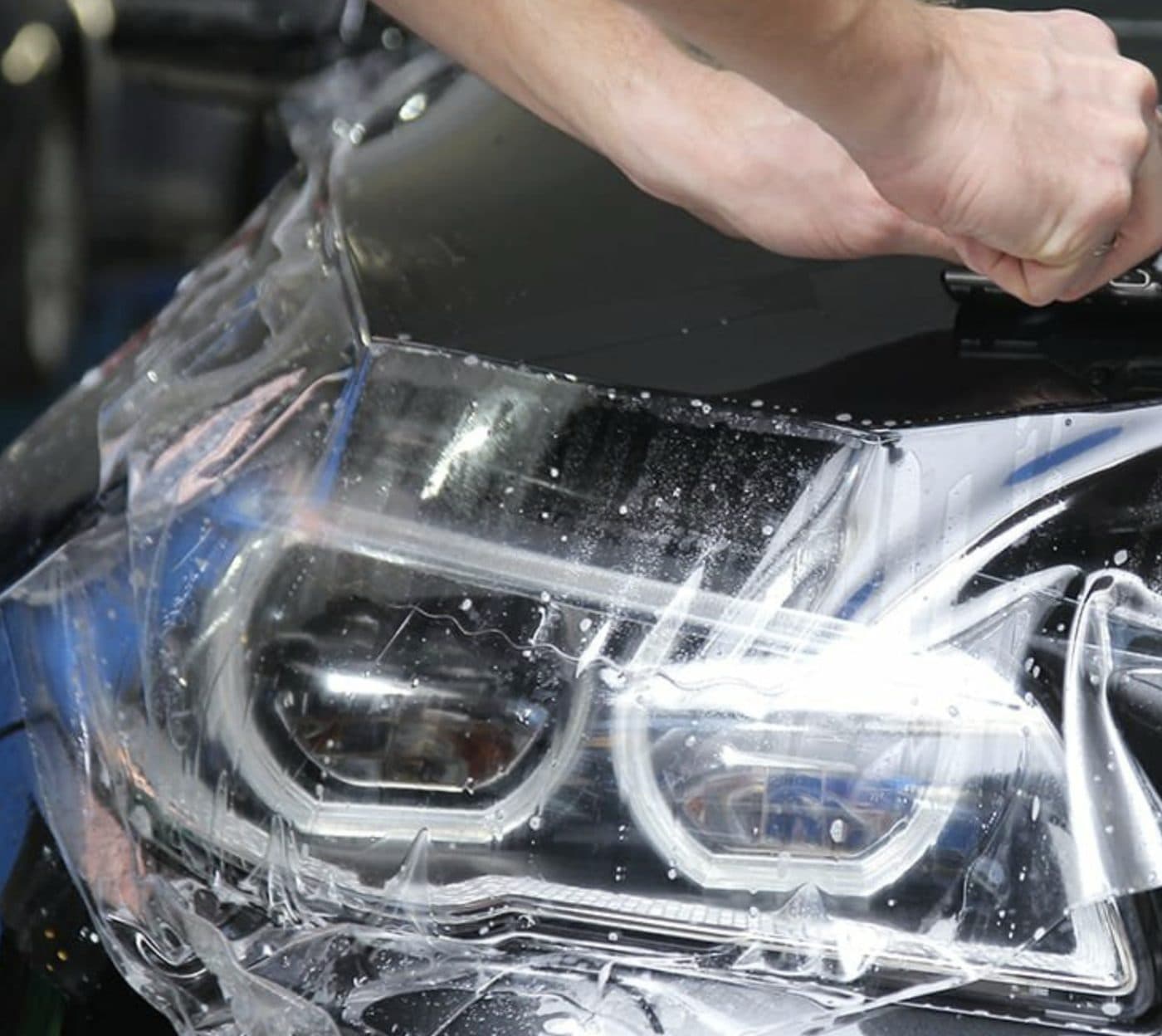 Clear PPF film being fitted to the headlight and front end of a car at the XWrap workshop in Valencia
