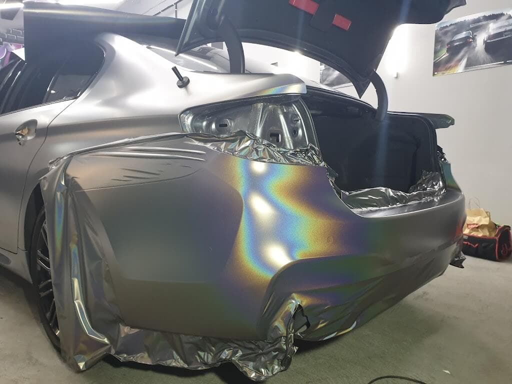 Lámina de vinilo camaleón colocada sobre el lateral trasero de un coche durante la instalación en el taller de XWrap en Valencia
