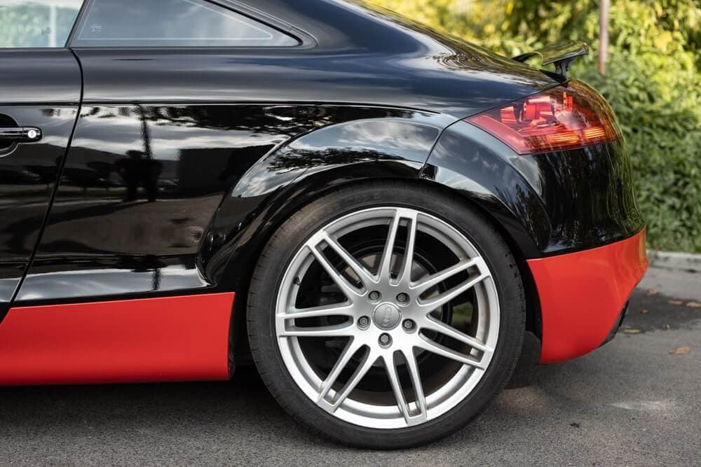 Rueda trasera y faldón rojo del Audi TT con vinilado parcial