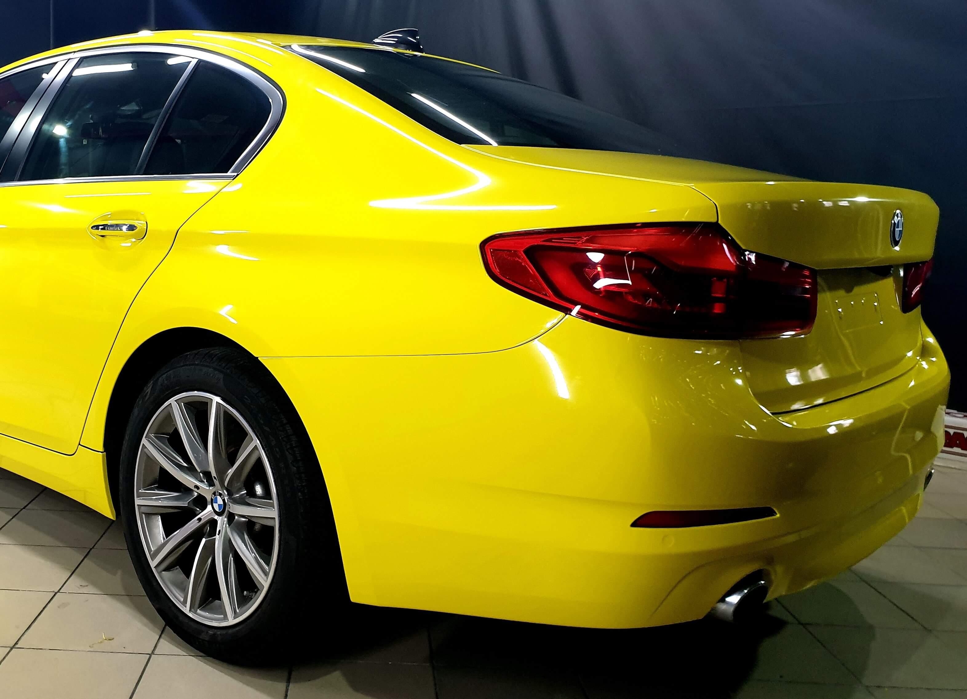 Parte trasera del BMW Serie 5 con carrocería vinilada en amarillo