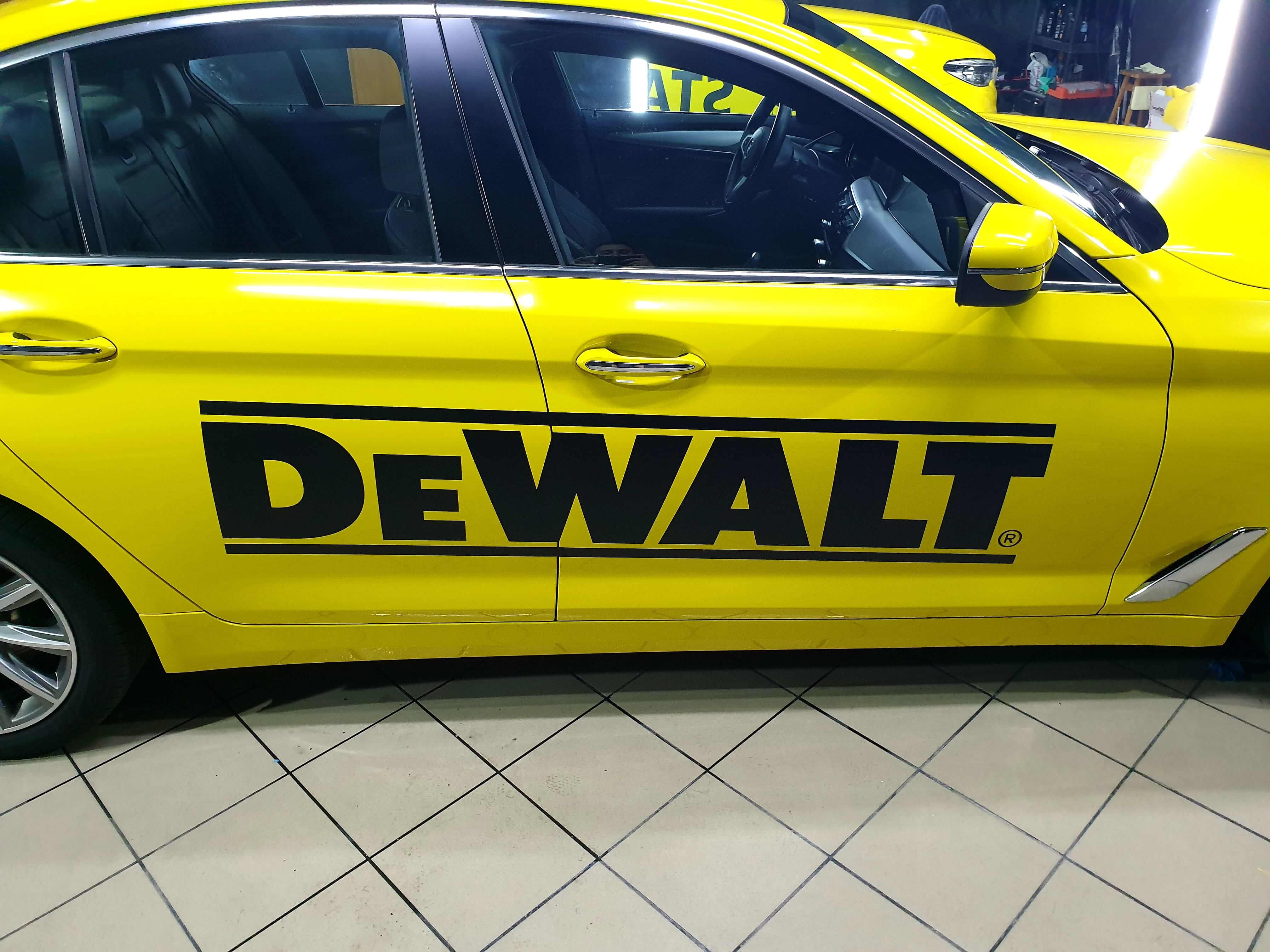 Puerta del BMW Serie 5 rotulada con el logotipo negro de DeWalt