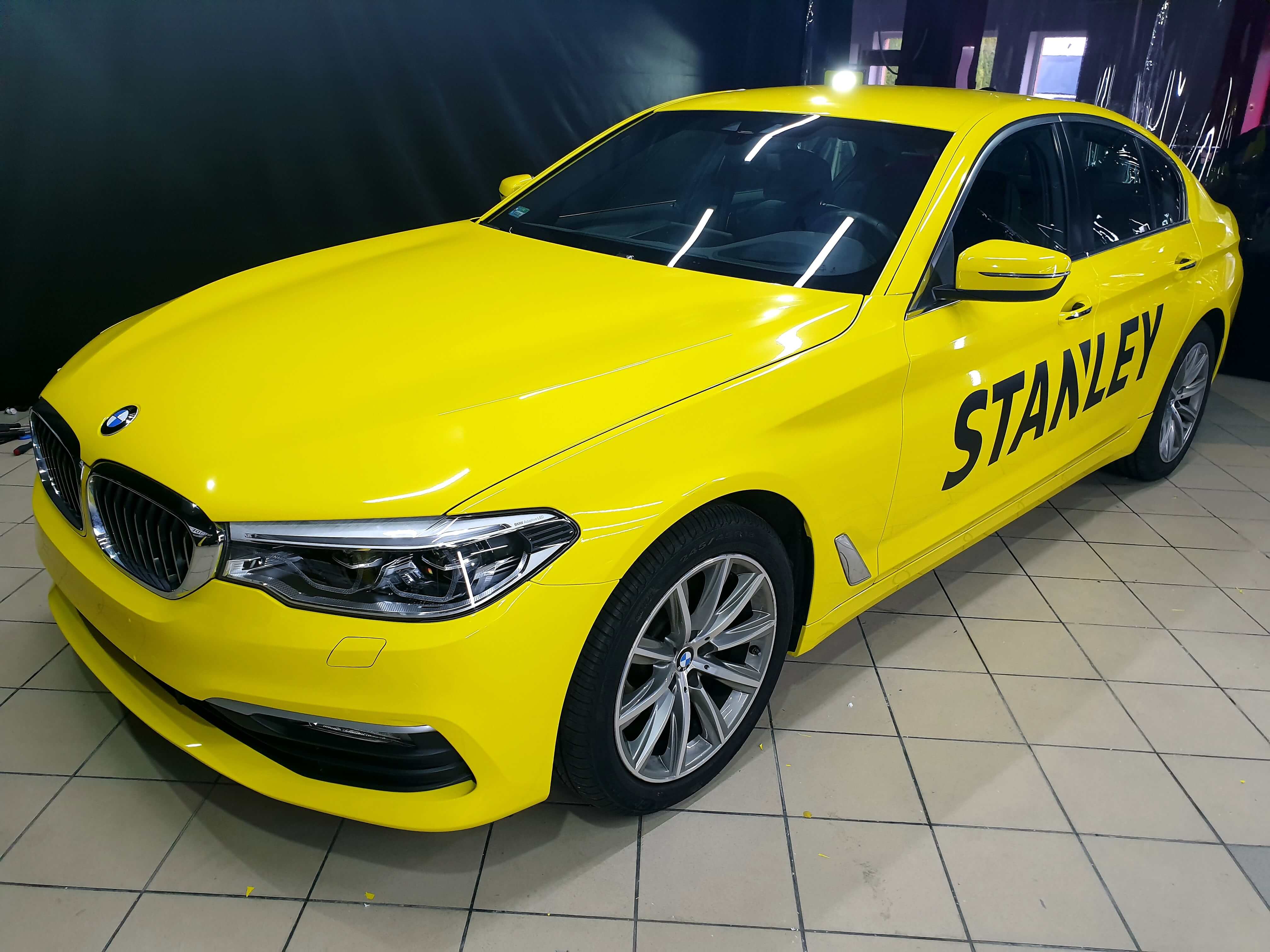 BMW Serie 5 amarillo con rotulación publicitaria de Stanley y DeWalt